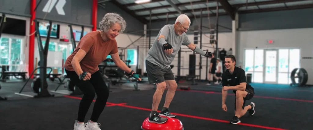 Older man and woman jumping at MOVMNT Personal Fitness